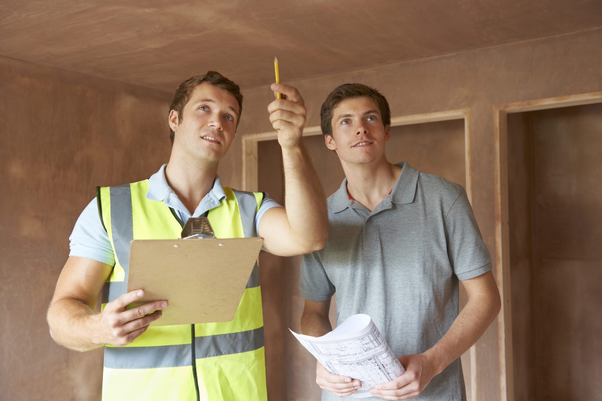 2 people checking roof and wall